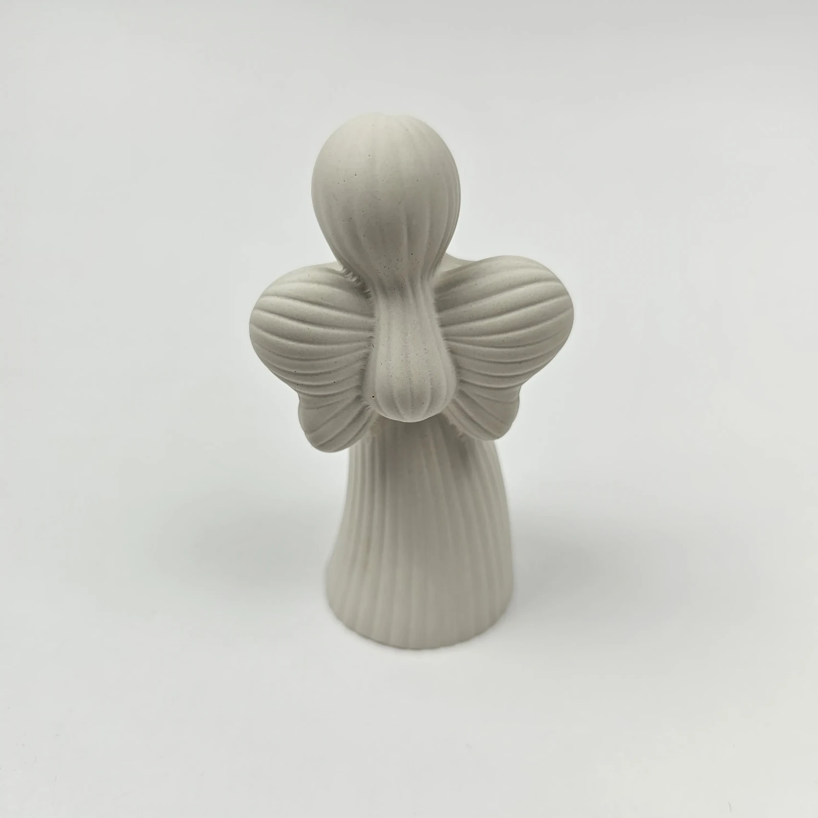 Tył figurki anioła z widoczną fakturą sukni i skrzydeł, rękodzieło