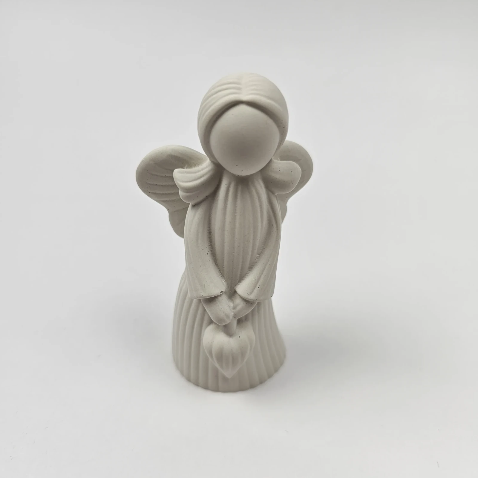 Ręcznie robiona figurka anioła z gipsu polimerowego trzymająca serce, widok z przodu