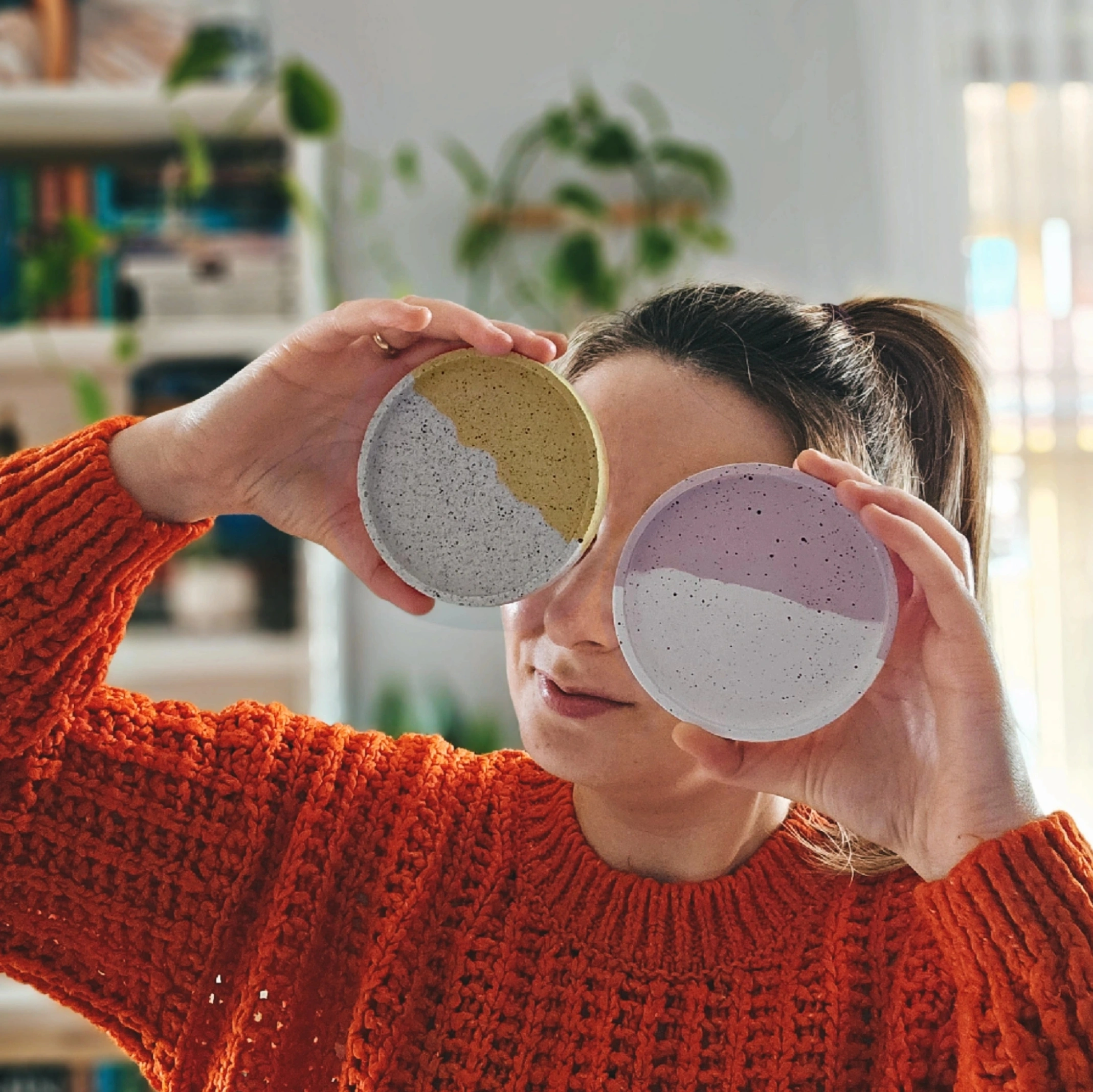 Twórczyni ArtyDzieła trzyma dwie ręcznie robione podstawki z gipsu polimerowego.