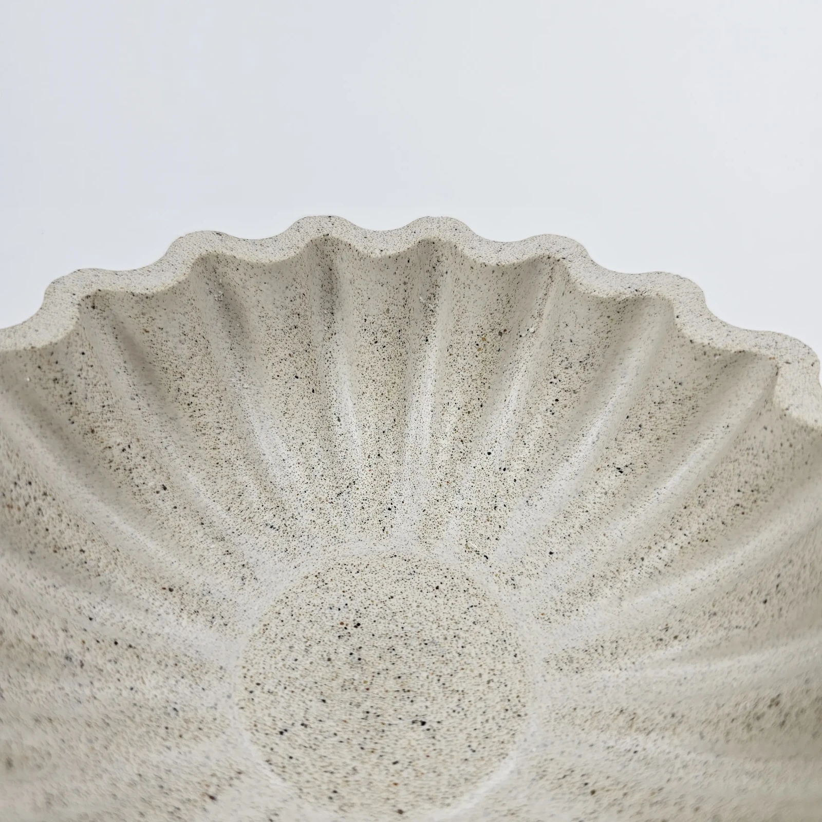 Zbliżenie na unikalną fakturę imitującą terrazzo, uzyskaną dzięki naturalnemu piaskowi nadmorskiemu.