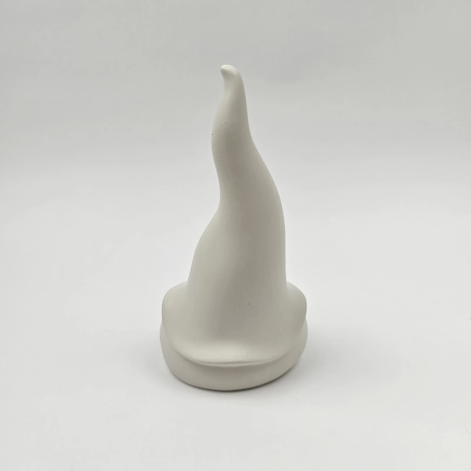 Tył figurki skrzata z gipsu polimerowego ukazujący falisty kształt czapki.