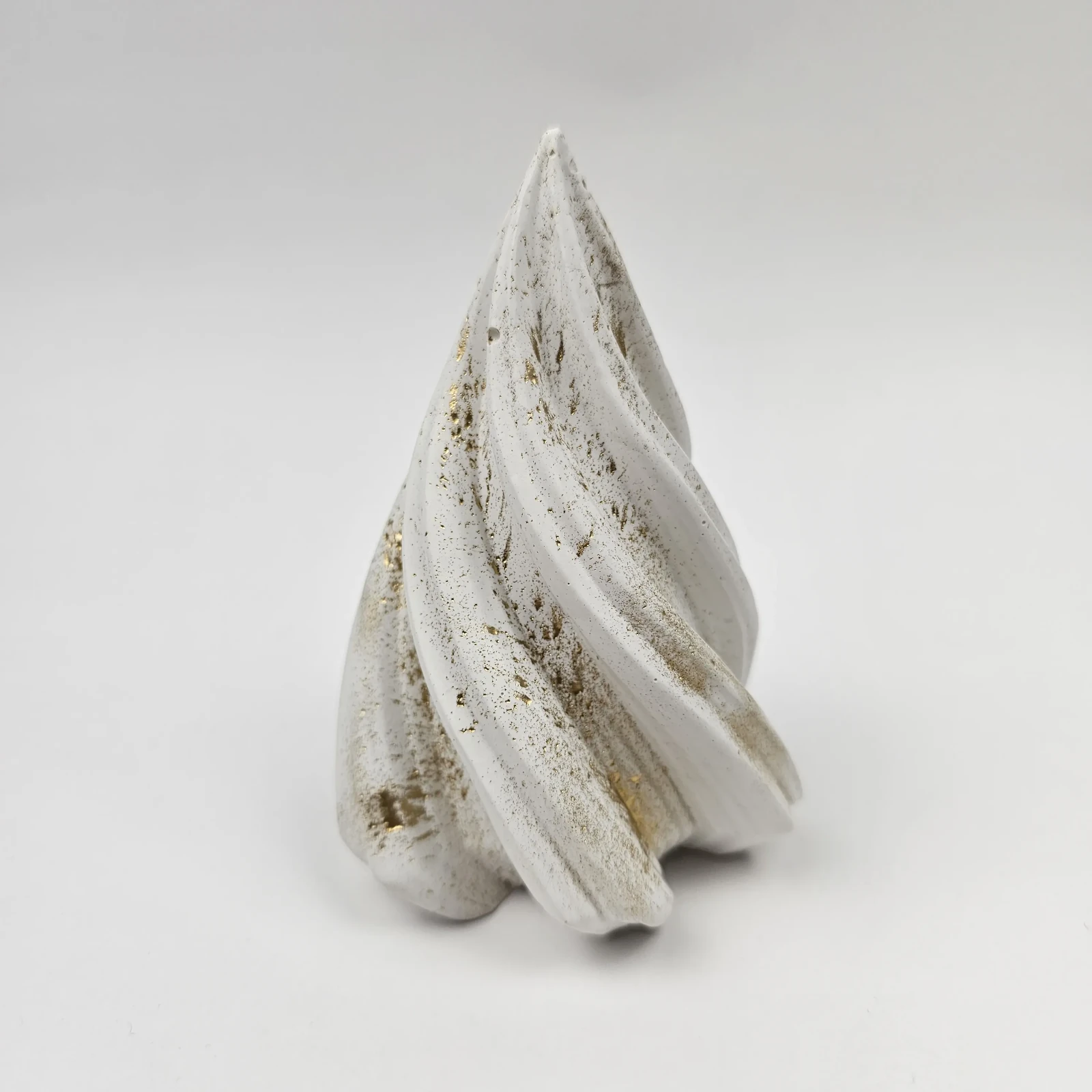 Minimalistyczna figurka choinki w stylu glamour z białego gipsu ze złotymi akcentami, widok z boku.