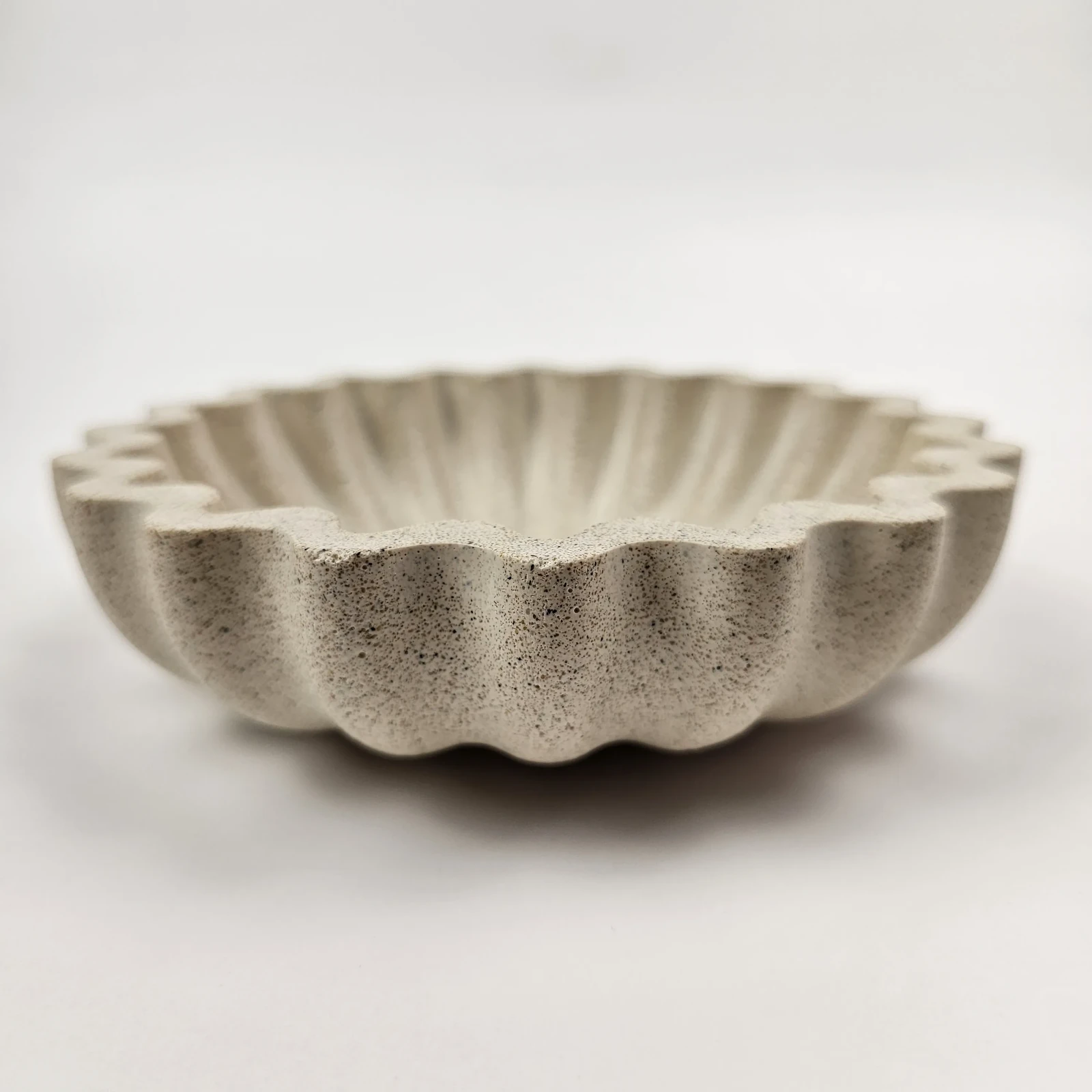 Boczne ujęcie ręcznie robionej podstawki z piaskiem, wykonanej z ekologicznego gipsu polimerowego.