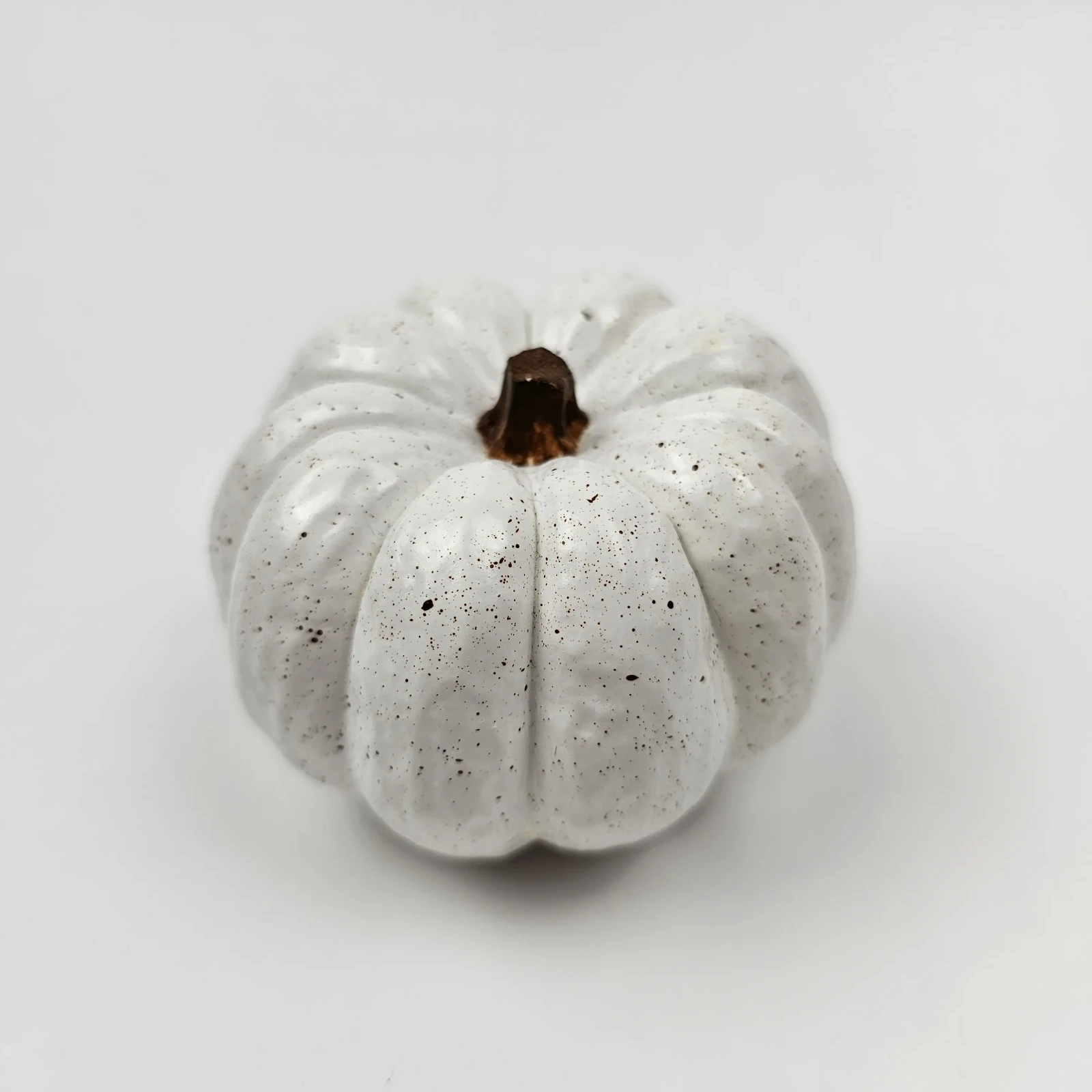 Mała dynia dekoracyjna z gipsu polimerowego w stylu lastryko na białym tle