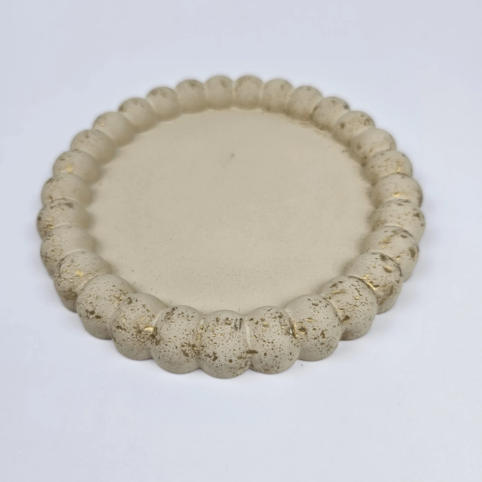 Ręcznie robiona okrągła podstawka typu bubble z gipsu polimerowego w kolorze beżowym ze złotymi zdobieniami, idealna na biżuterię.