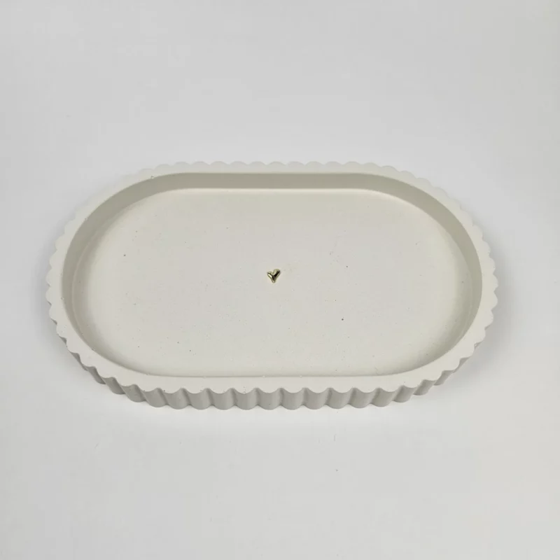 Beżowa owalna podstawka z gipsu polimerowego ze złotym serduszkiem na środku, idealna na biżuterię.