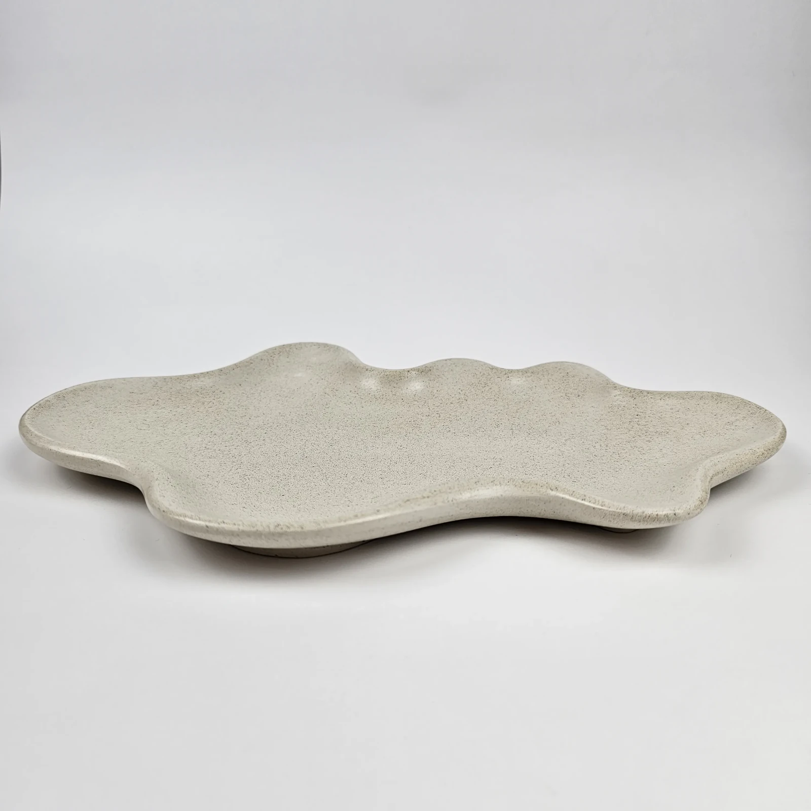 Boczny profil falistej podstawki na biżuterię z widoczną fakturą naturalnego piasku i matowym wykończeniem