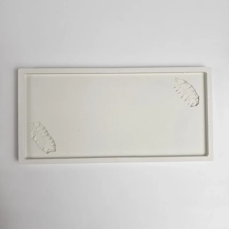 Biała prostokątna taca z gipsu polimerowego z odciśniętym motywem liści, ręcznie robiona podstawka na biżuterię.