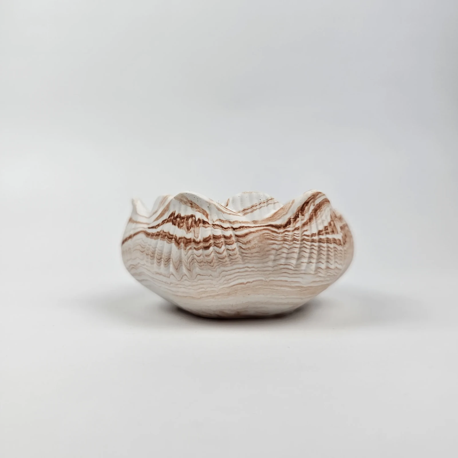 Profil boczny świecznika tealight z gipsu polimerowego ukazujący fakturę inspirowaną muszlą.