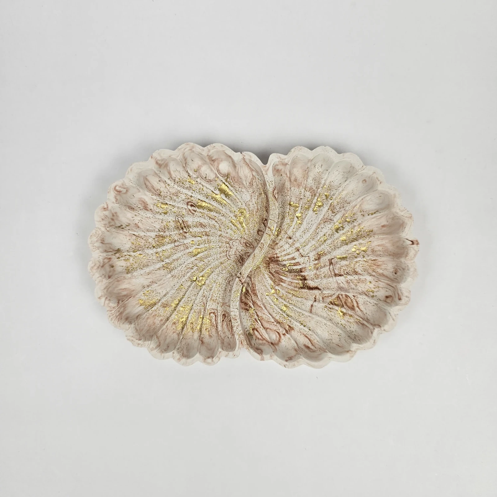Widok z góry na ozdobną tacę muszlę z gipsu polimerowego w stylu glamour, beżowa z brązowymi smugami i złotem.