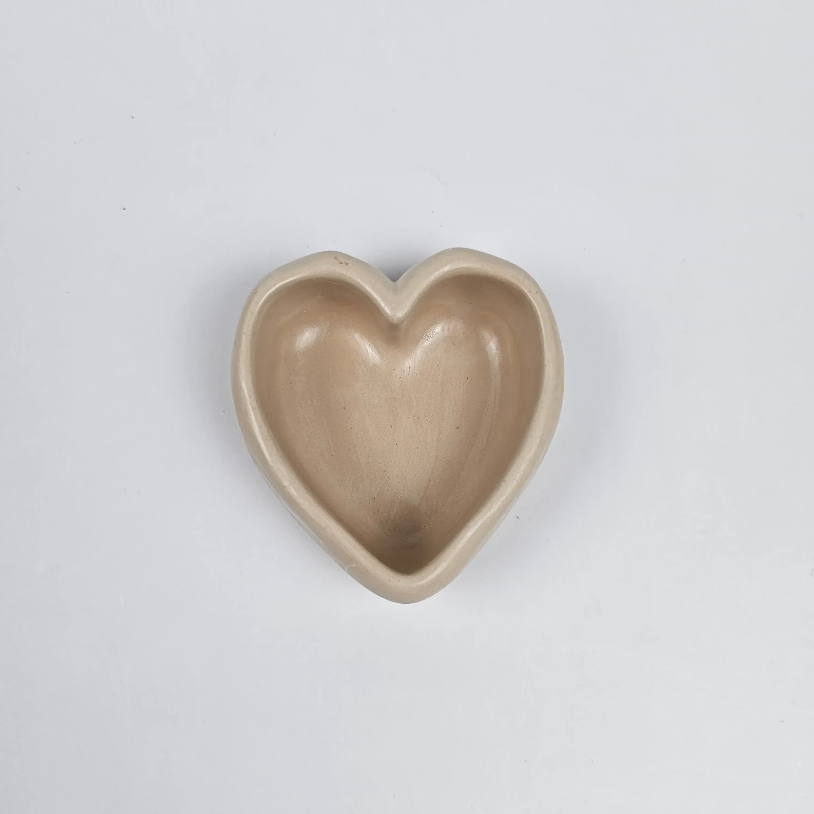 Ręcznie robiona tacka serce z gipsu polimerowego na biżuterię i pierścionki, widok z góry, kolor beżowy.