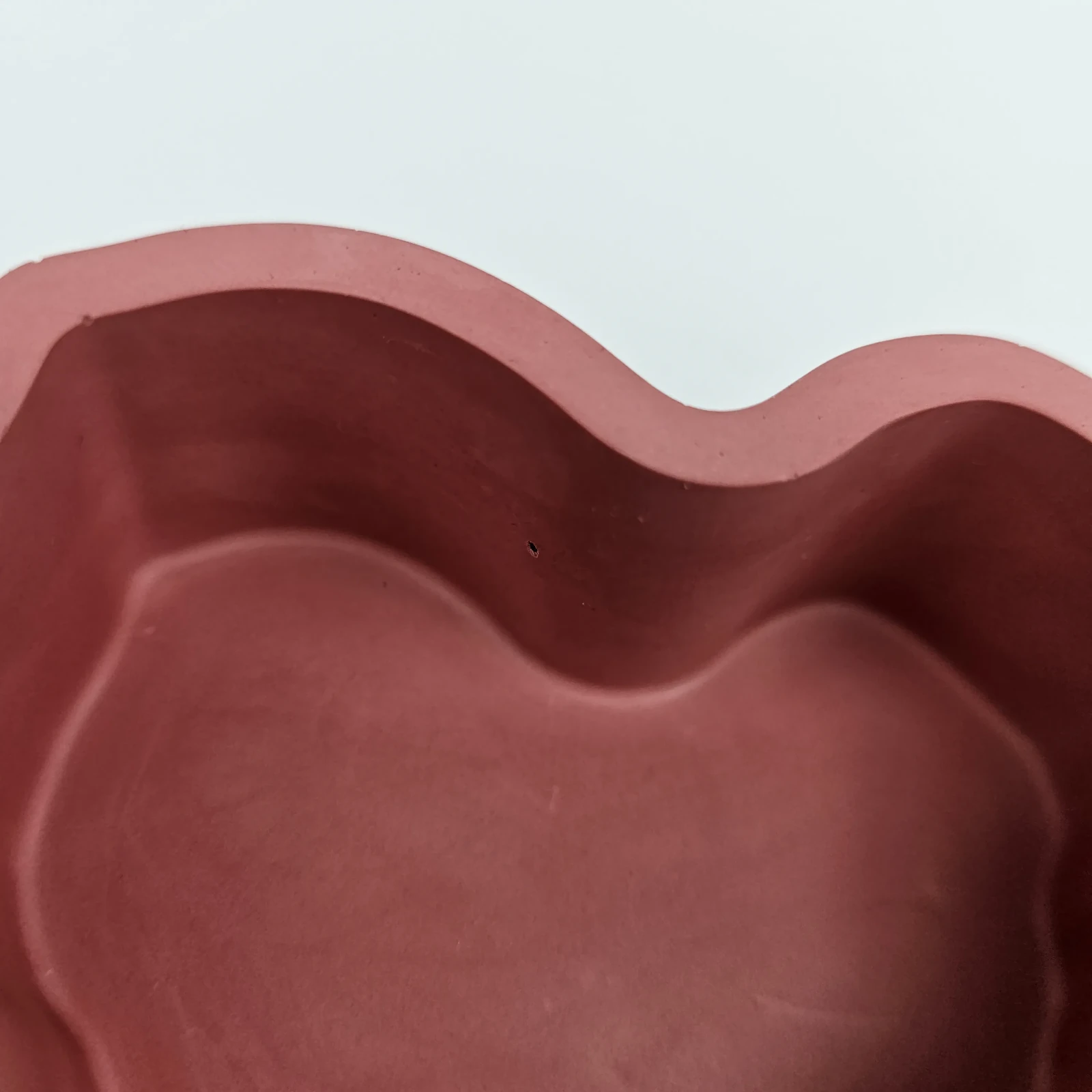 Wnętrze bordowej szkatułki w kształcie serca wykonanej z gipsu polimerowego